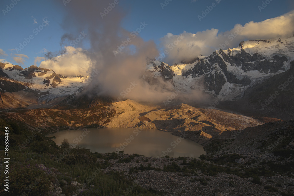 Summer views of the snowy mountains of the Caucasus. Formation and movement of clouds over mountains peaks.