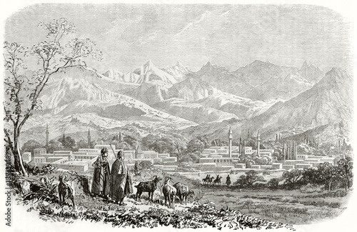 Ancient large view view of Tarsus and Taurus mountains in background Cilicia (in our day Turkey), oriental style city and shepherds directed to it. By Grandsire published on Le Tour du Monde 1862 photo