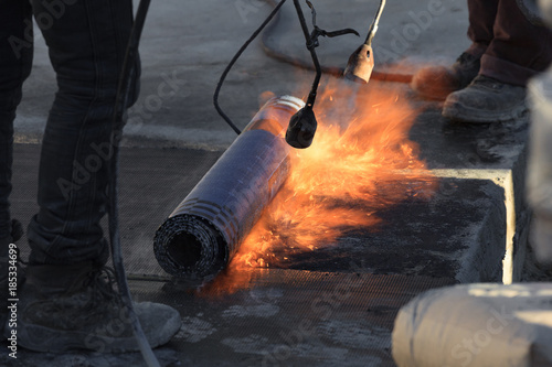 Laying of roofing felt from the roll with a flame from the burner close-up. photo