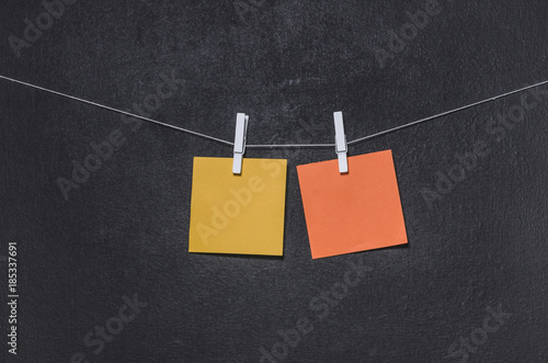 Bright colored stickers on a rope on a dark background with free copy space