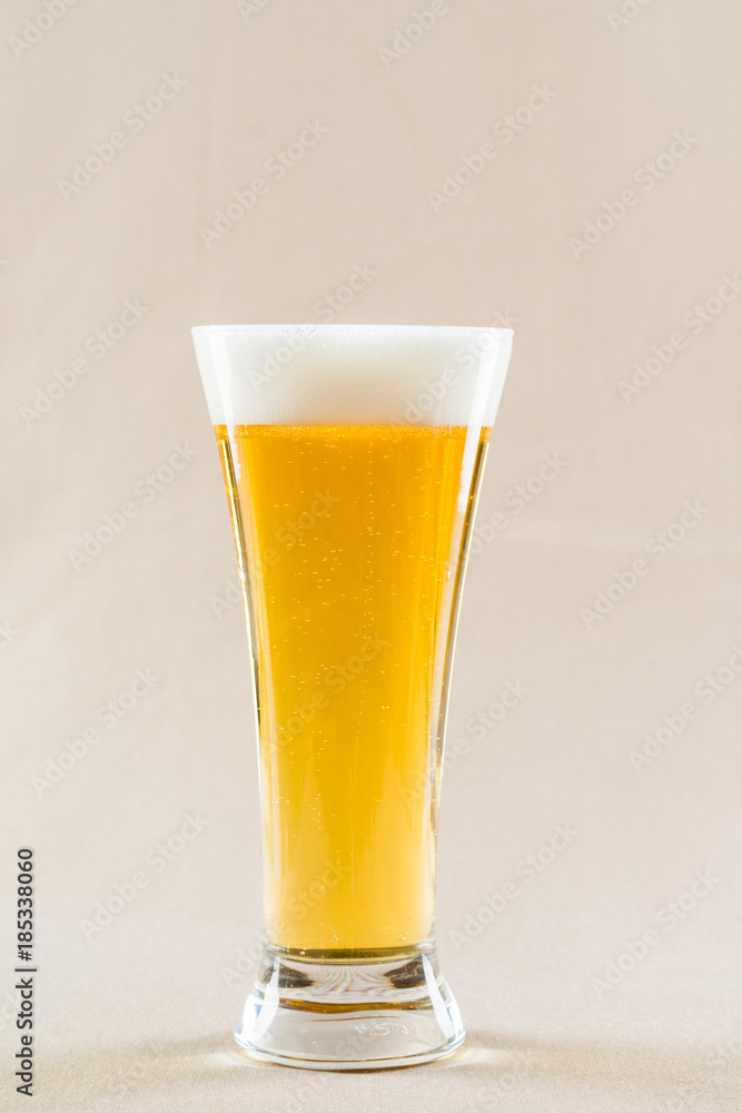 glass of light beer on light background glass of light beer on light background