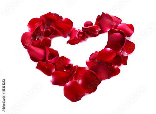 A red heart is formed by rose petals.