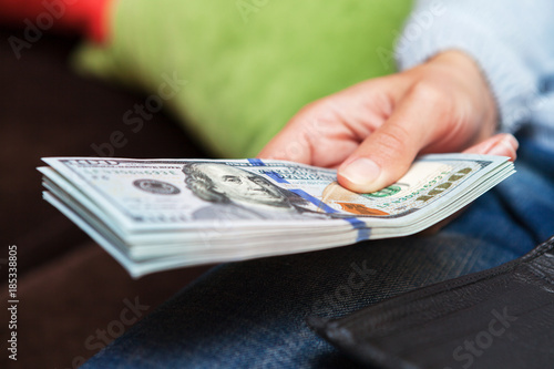 money in hands for a girl sitting on a sofa