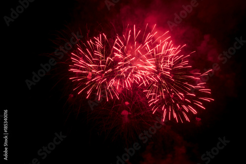 Red fireworks in night sky.