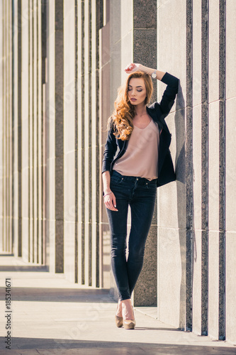 Outdoors fashion portrait of trendy pretty girl posing on the wall background. © forget_me_not_18