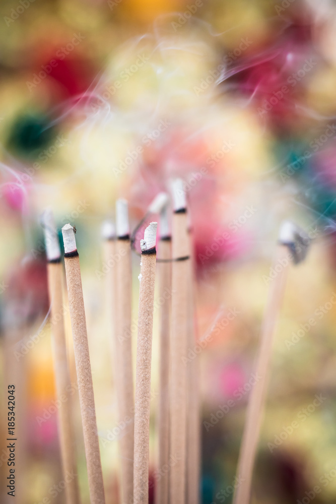 Incense smoke and colorful blurry background Incense smoke and colorful blurry background