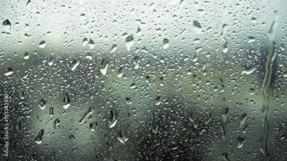 Drops of rain on a window pane, buildings in background Drops of rain on a window pane, buildings in background