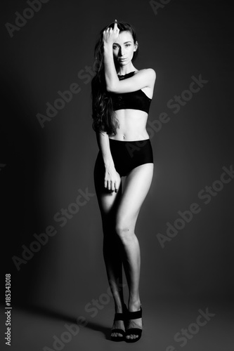 Young sexy woman in studio. Black and white background