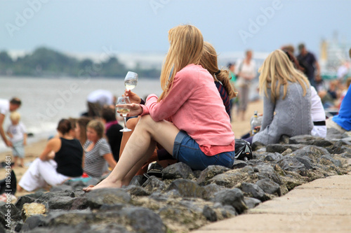 junge Frauen mit Weinglas feiern am Elbstrand bei bedecktem Himmel.Where: Hamburg, Elbe.When: 29.07.2013.