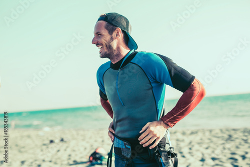 Smiling Caucasian man kitesurfer on the beach