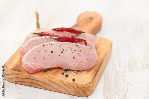 raw pork with black and red pepper on wooden board