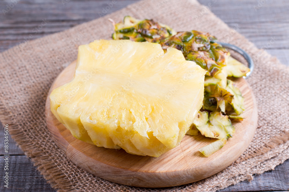 Cutting fresh pineapple on old wooden background Cutting fresh pineapple on old wooden background