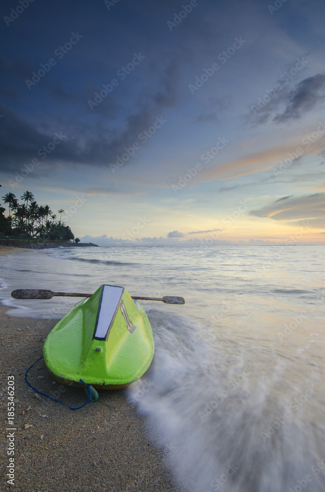 Green canoe at senggigi beach sunset, lombok island, indonesia Green canoe at senggigi beach sunset, lombok island, indonesia
