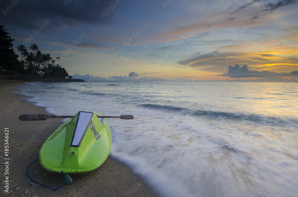 Green canoe at senggigi beach sunset, lombok island, indonesia Green canoe at senggigi beach sunset, lombok island, indonesia