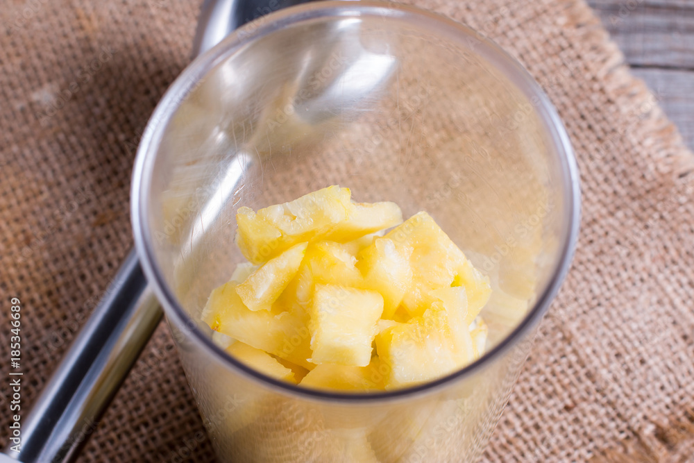 Pineapple slices in a blender on the table Pineapple slices in a blender on the table