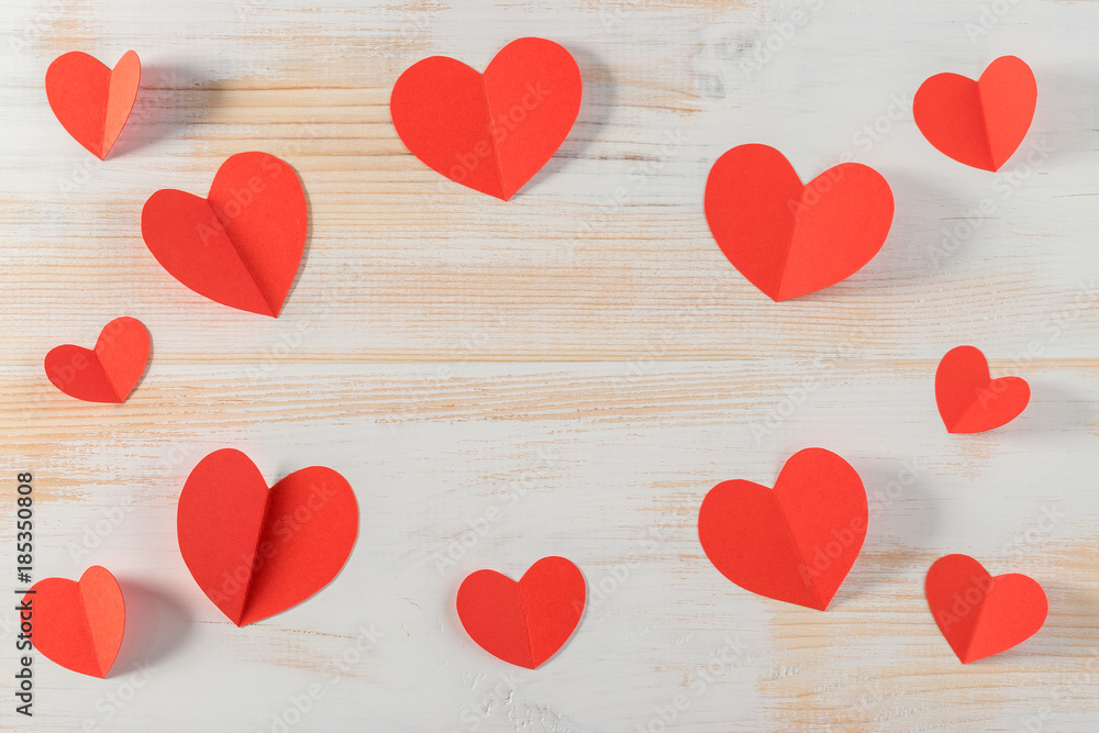 Red paper hearts on wooden background. Valentines day.