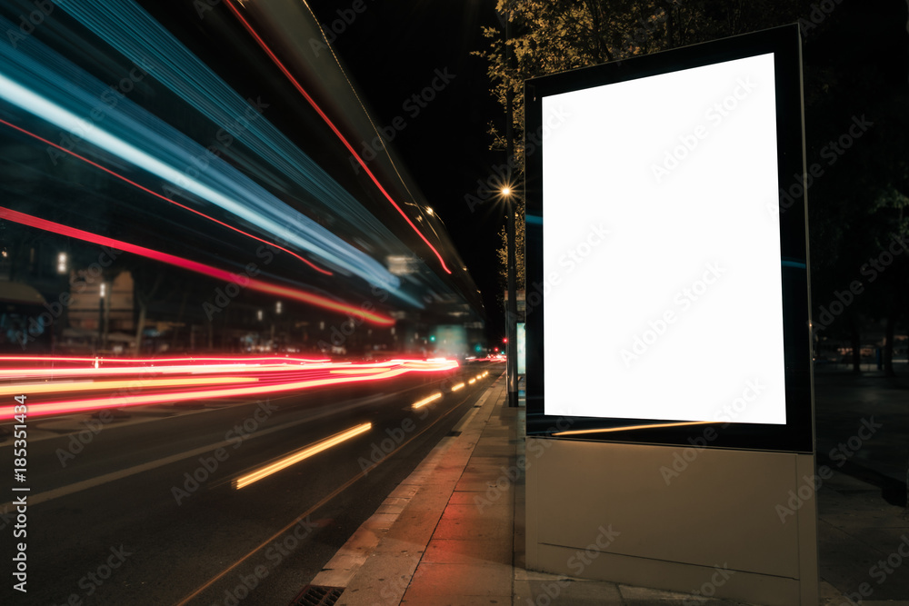 Blank white advertisement lightbox at night. Mock-up design concept. Car lights. Blank white advertisement lightbox at night. Mock-up design concept. Car lights.