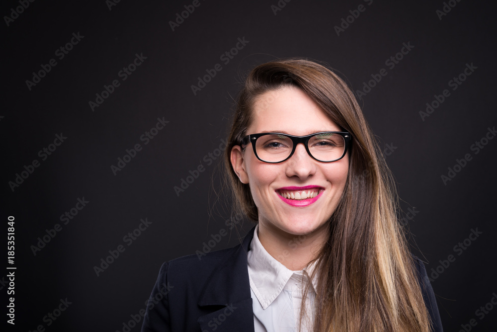 Smiling female manager posing on dark background Smiling female manager posing on dark background
