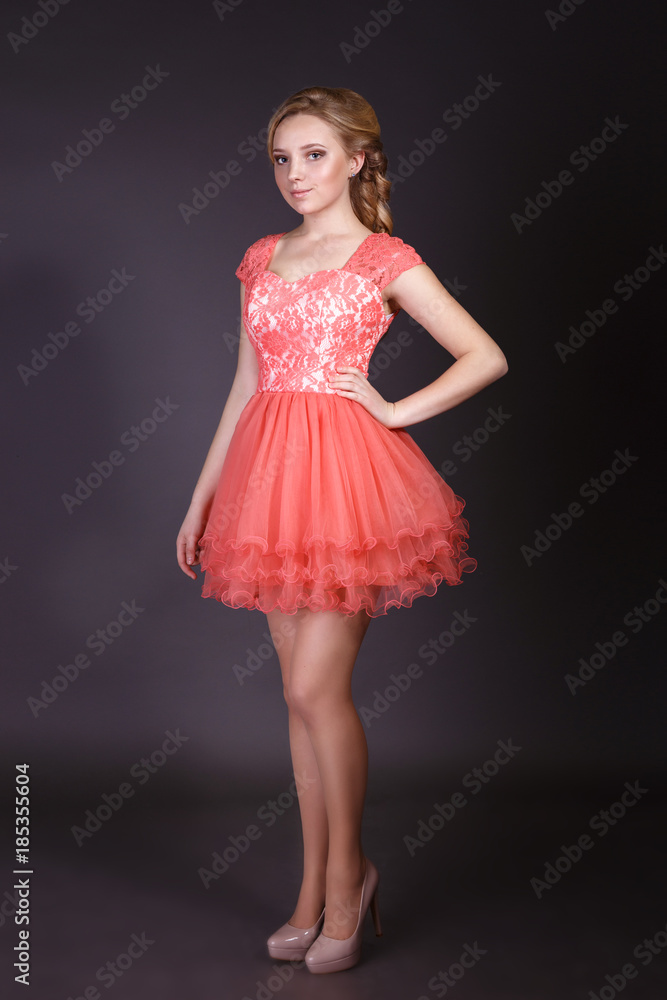 Fashion studio shot of beautiful woman with makeup and hairstyle wearing evening dress Fashion studio shot of beautiful woman with makeup and hairstyle wearing evening dress