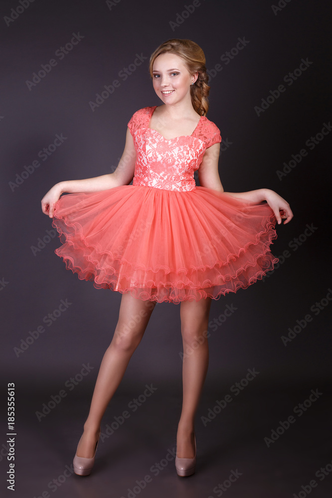 Fashion studio shot of beautiful woman with makeup and hairstyle wearing evening dress Fashion studio shot of beautiful woman with makeup and hairstyle wearing evening dress