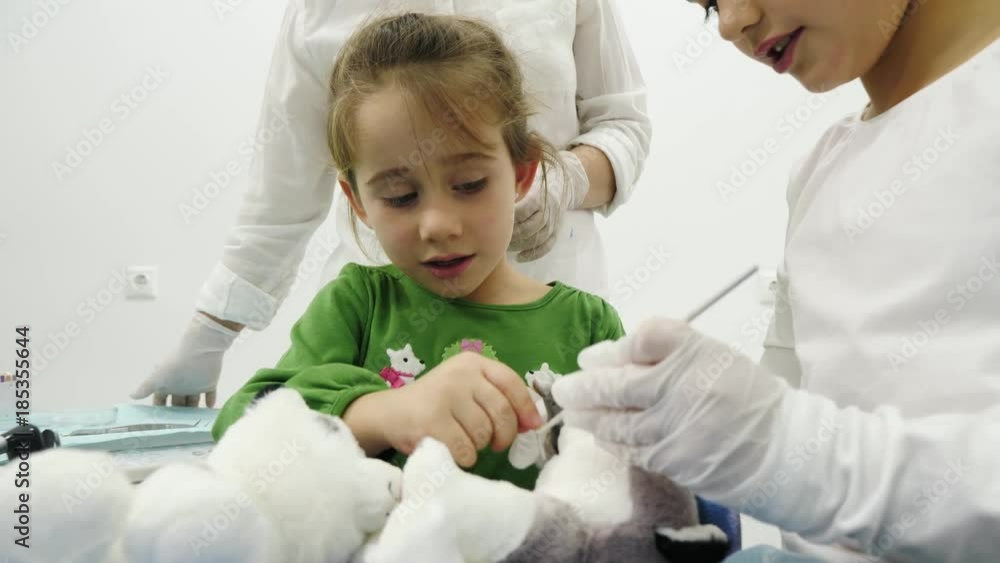 Two little girl play the roles of dentist during a dental check-up Two little girl play the roles of dentist during a dental check-up