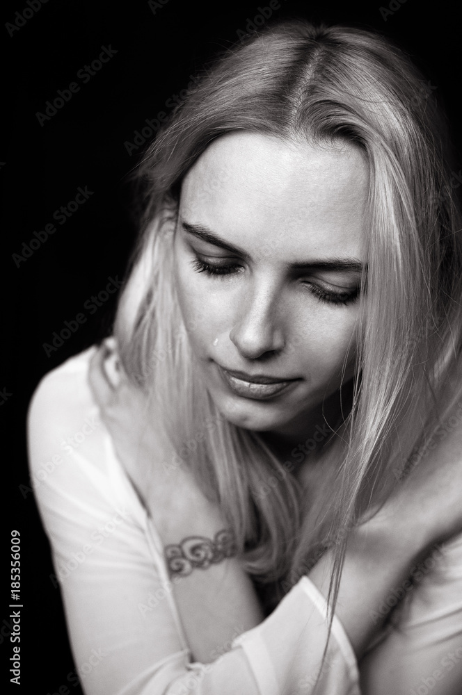 Beautiful girl cries, demonstrating her sadness and emotions. Black and white photo depicting a blonde model is upset in depression. Beautiful girl cries, demonstrating her sadness and emotions. Black and white photo depicting a blonde model is upset in depression.