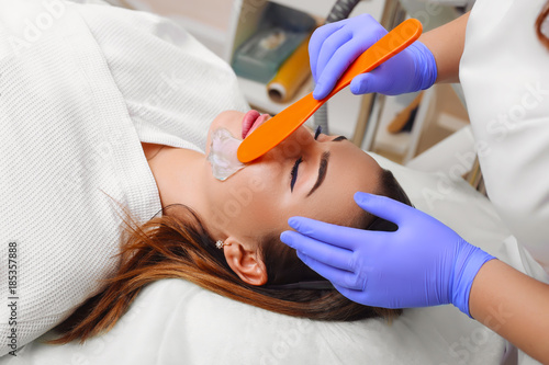 Applying cosmetic gel on the face patient.