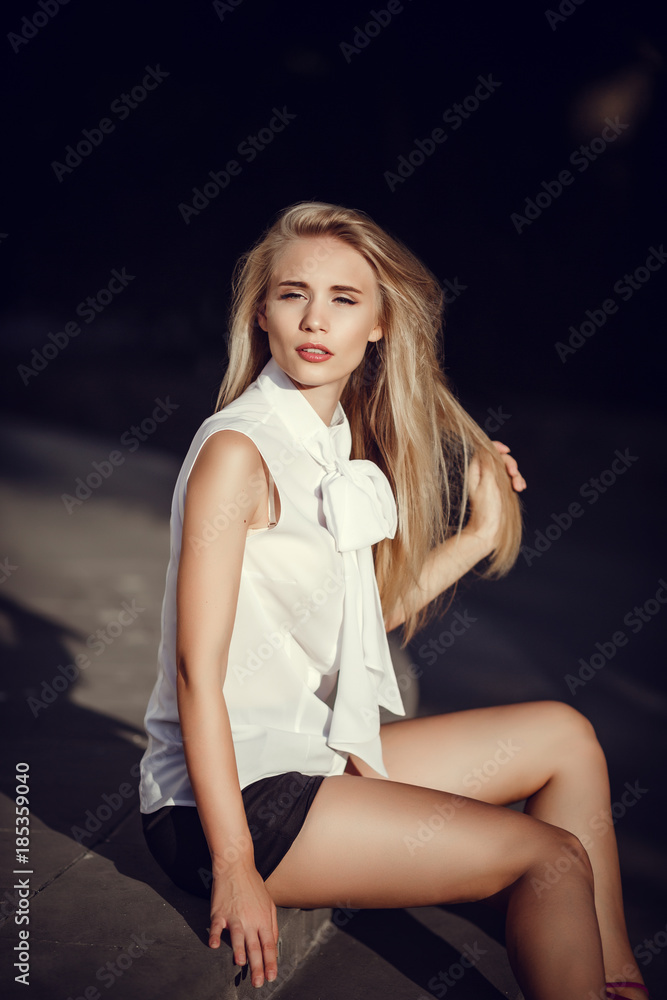 Fototapeta premium Outdoor portrait of a young beautiful fashionable lady walking on street.