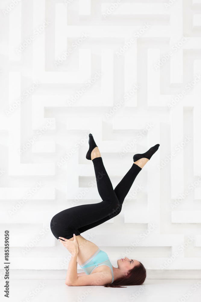 Side view of sporty young woman practicing advanced yoga, pilates Side view of sporty young woman practicing advanced yoga, pilates