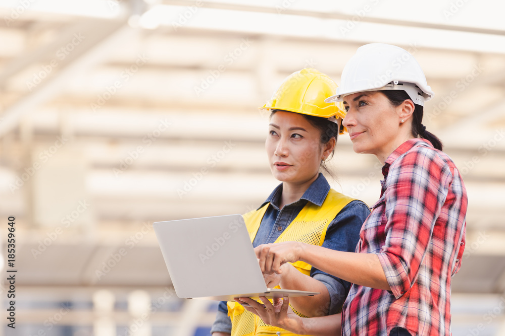 Engineers two woman working on plan building construction with laptop in city Engineers two woman working on plan building construction with laptop in city