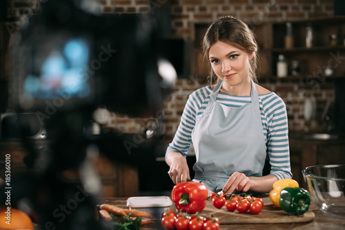young food blogger cutting cherry tomatoes