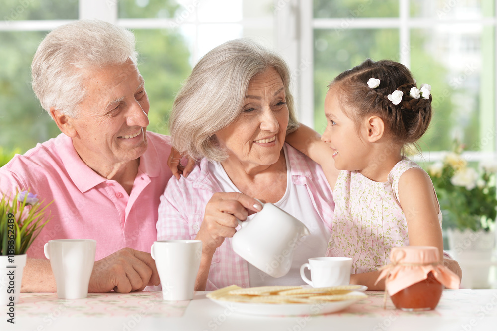 grandparents with granddaughter drinking tea grandparents with granddaughter drinking tea
