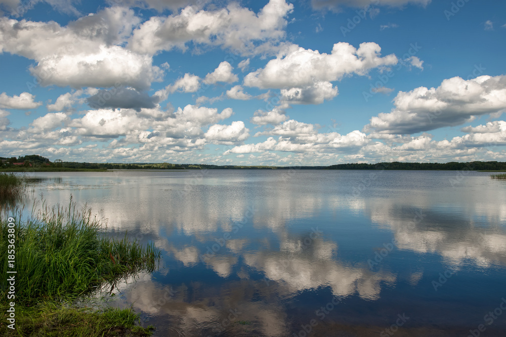 Lake on a summer day with clouds reflected in the water
