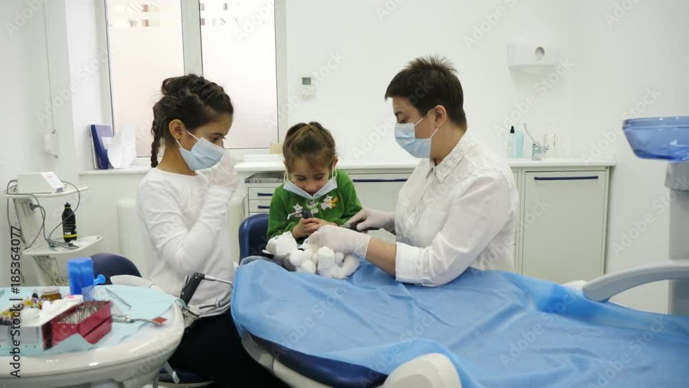 A dentist give to children a dentist mask for play the roles of dentist during a dental check-up