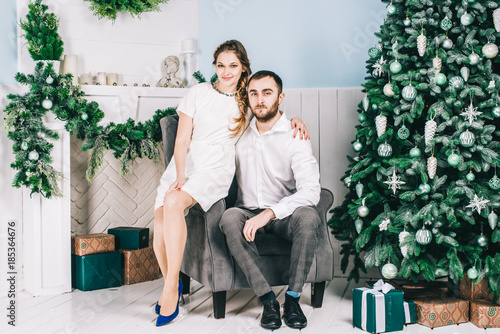 Lovely couple sitting near the Christmas tree. Christmas and New Year concept