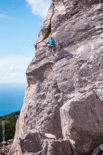 A rock climber on a wall. © zhukovvvlad