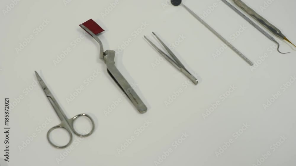 Dental instruments in dental cabinet. Close Up of medical instruments. On the table lies excavators dental, articulating tweezers curved, scissors, mouth mirror, syringe, college tweezers. Dental instruments in dental cabinet. Close Up of medical instruments. On the table lies excavators dental, articulating tweezers curved, scissors, mouth mirror, syringe, college tweezers.