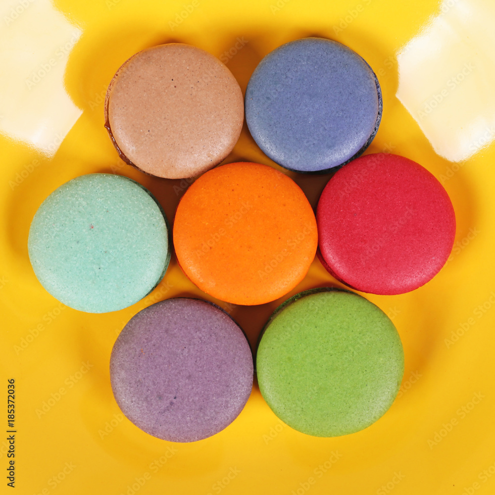 Tasty delicious macaroons biscuits on yellow plate Tasty delicious macaroons biscuits on yellow plate