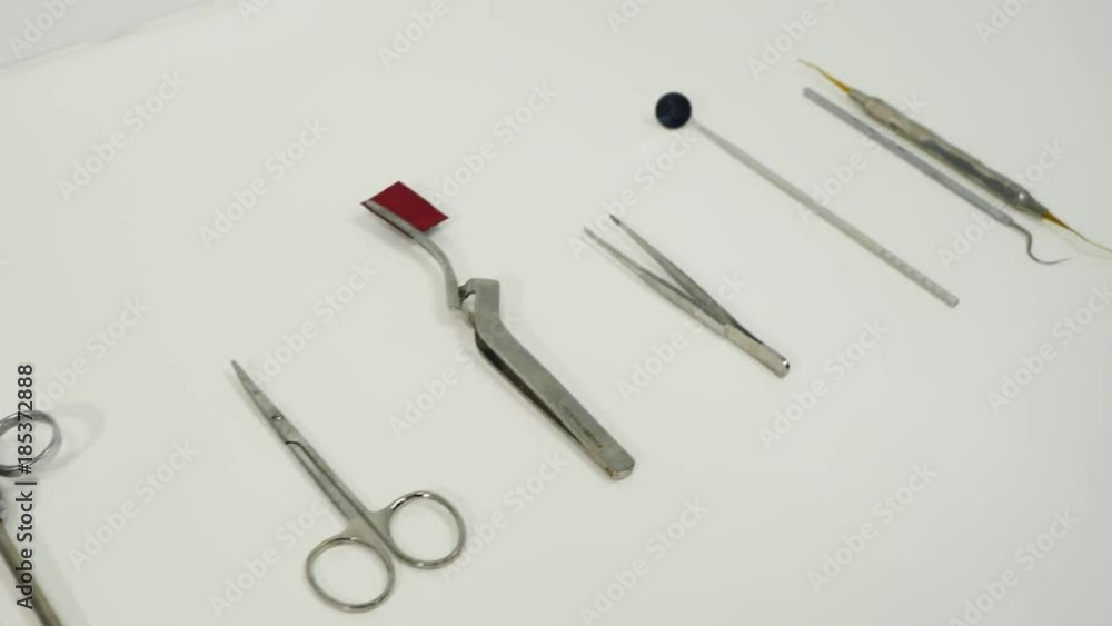 Dental instruments in dental cabinet. Close Up of medical instruments. On the table lies excavators dental, articulating tweezers curved, scissors, mouth mirror, syringe, college tweezers. Dental instruments in dental cabinet. Close Up of medical instruments. On the table lies excavators dental, articulating tweezers curved, scissors, mouth mirror, syringe, college tweezers.