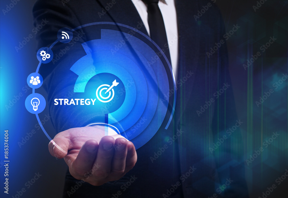 Business, Technology, Internet and network concept. Young businessman working on a virtual screen of the future and sees the inscription: Strategy Business, Technology, Internet and network concept. Young businessman working on a virtual screen of the future and sees the inscription: Strategy