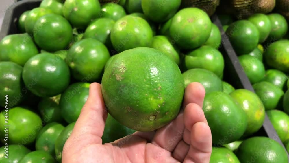 Man hand choosing a green organic mandarins at the farmer supermarket. Man hand choosing a green organic mandarins at the farmer supermarket.