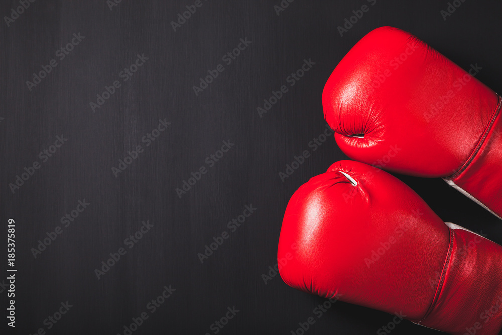 Professional red boxing gloves on black background with copy space.