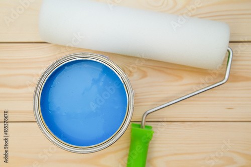 A can of blue paint and a paint roller photo