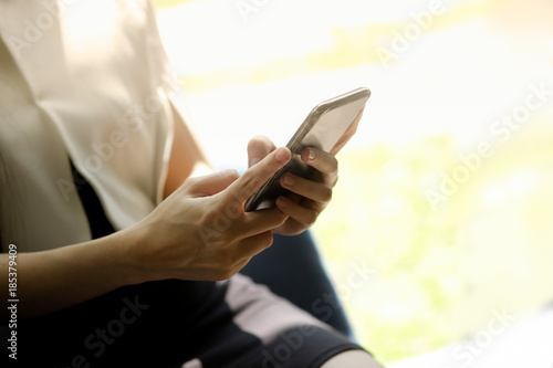 Cropped shot of an unrecognizable businesswoman using a mobile phone at office.