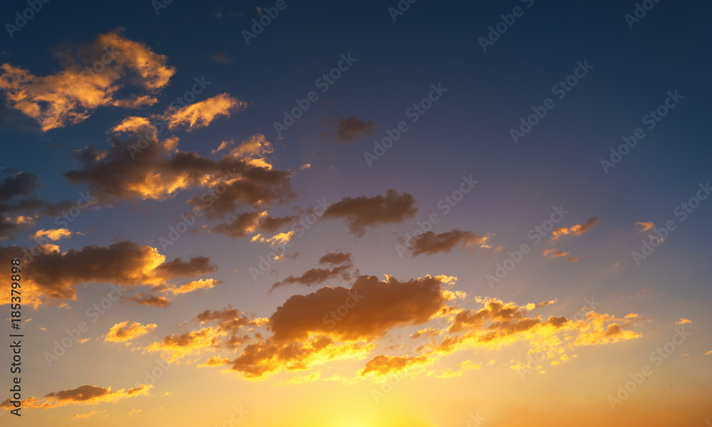 Sky background at sunset,Sky blue and orange light of the sun through the clouds in the sky Sky background at sunset,Sky blue and orange light of the sun through the clouds in the sky