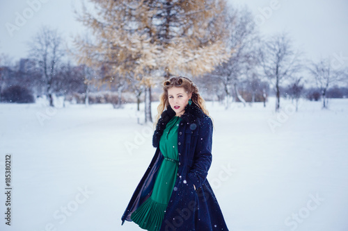 Young beautiful woman walking in a park and breathing fresh winter air and feeling wonderful