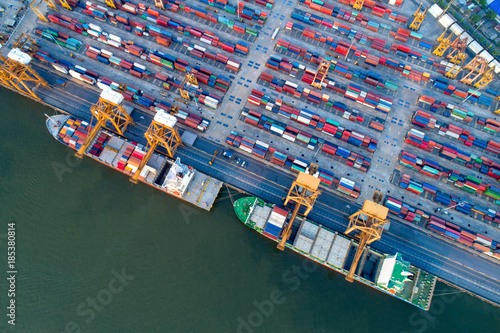 Containers yard in port congestion with ship vessels are loading and discharging operations of the transhipments in international port.