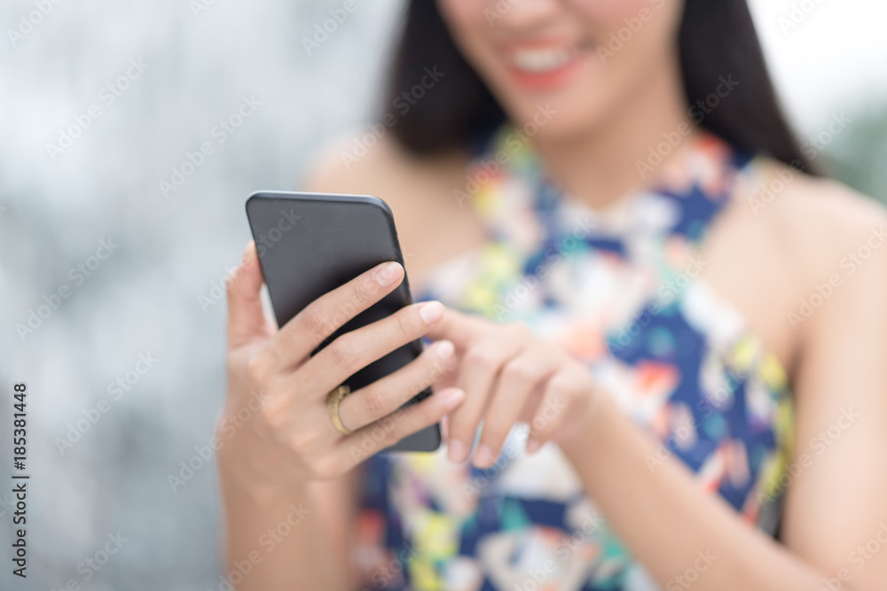 woman in white santa's hat  using smartphone against blur background