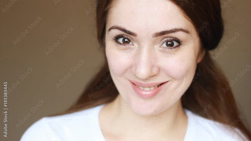 Happy face young woman close-up portrait. Beautiful brunette girl smiles and looks at the camera. Happy face young woman close-up portrait. Beautiful brunette girl smiles and looks at the camera.
