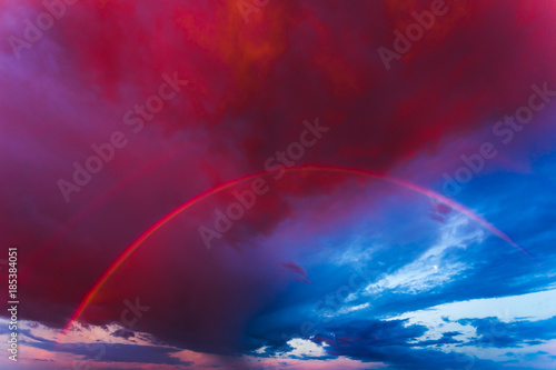 Double rainbow in the purple evening sky © lukjonis